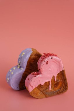 Kalp, pembe arka planda fotokopi alanı olan iki ay çöreği şekillendirdi. Puf puf yeni moda tatlı pastanesi. Kremalı hamur deneyi 