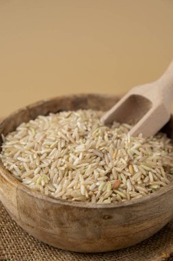Tarafsız bej arka planda esmer pirinç kopyalama alanı. Tam hecelenmiş tahıl türü. Yüksek proteinli lif zengini vejetaryen gıda bileşeni. Glütensiz süper yiyecek sağlıklı beslenme alternatifi
