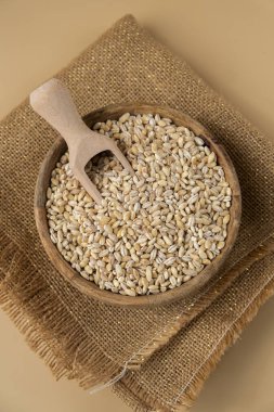 Tarafsız bej arka planda inci arpa. Tam hecelenmiş tahıl türü. Yüksek proteinli lif zengini vejetaryen gıda bileşeni. Glütensiz süper yiyecekler sağlıklı beslenme alternatifleri 