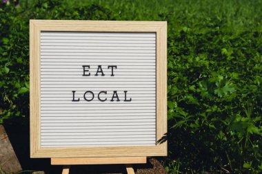 Çevre dostu, yeşil maydanozlu maydanozun arka planındaki lokal mesajı ye. Kırsal gıda üretim konsepti. Yerel olarak hasat üretiliyor. Sürdürülebilirlik ve sorumluluk 