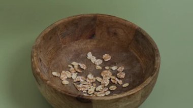 Yeşil arka planda çiğ yulaf lapası kopyalama alanı. Tam hecelenmiş tahıl türü. Yüksek proteinli lif zengini vejetaryen gıda bileşeni. Glütensiz süper yiyecek sağlıklı beslenme alternatifi