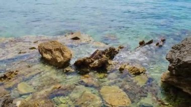 Karadağ 'ın Budva kenti yakınlarındaki katmanlı kayalar arasında güzel kayalar ve parlak turkuaz su bulunuyor. Adriyatik Denizi 'ndeki tropik yaz manzaralı egzotik plajlar. Tatil fikri. 