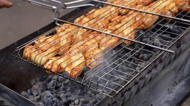 Barbeküde ızgara ızgarada kızarmış tavuk. Baharat taze ızgara tavuk kanatlarına dökülüyor. Yaz partisi yemekleri. Barbekü Sulu ızgara ızgarada kızarmış tavuk budu. 