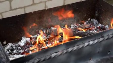 Barbekü ızgarasında alevler arka bahçede boş zaman aktiviteleri. Yaz tatili partisi kavramı Yavaş çekim yanan odunları bbq yemek pişirmeye hazırlıyor Yaz zamanı