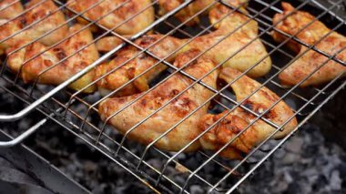 Barbekü pikniği zamanı kızarmış tavuk budu ve ızgarada kanat. Bahçe ızgarasında ızgara et. Bahçe bahçesinde yaz mevsiminde ızgara ızgara ızgara ızgara tavuk bifteği, dumanlı, sulu et.