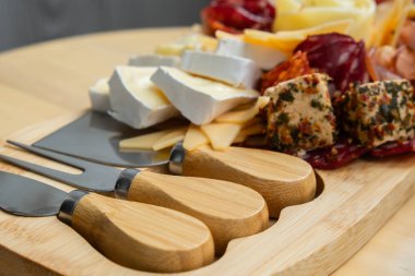 Gıda trend hediye aperatifi parti fikri. Aperatifler ahşap otlatma tahtası ile farklı şarküteri aperatifleri ve peynirler. Çeşit çeşit peynir tabağı. Düzensiz yemek. Kız yemeği.