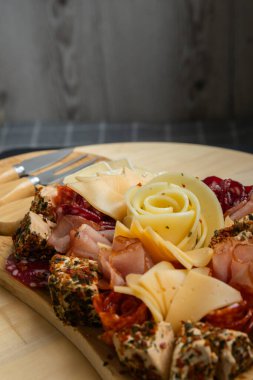 Gıda trend hediye aperatifi parti fikri. Aperatifler ahşap otlatma tahtası ile farklı şarküteri aperatifleri ve peynirler. Çeşit çeşit peynir tabağı. Düzensiz yemek. Kız yemeği.