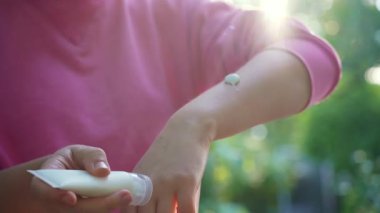 Böcek ısırığından sonra şişmiş cilt için krem ya da merhem kullanan tanınmayan bir kadın. Yaz mevsiminde sivrisinek ısırığına karşı koruma. Açık havada cilt bakımı