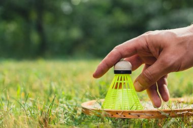 Badminton raketi ve mekik horozu yeşil çimlerin üzerinde yatar. Eğlence ve temiz hava dışında. Sağlıklı yaşam tarzı doğal bağlantı sporu yaz aktiviteleri. Stres atma hobisi sağlık hizmetleri