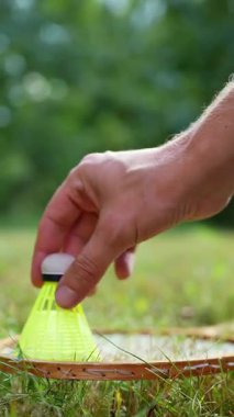 Badminton raketi ve mekik horozu yeşil çimlerin üzerinde yatar. Eğlence ve temiz hava dışında. Sağlıklı yaşam tarzı doğal bağlantı sporu yaz aktiviteleri. Stres atma hobisi sağlık hizmetleri