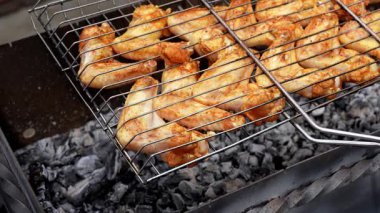 Barbeküde ızgara ızgarada kızarmış tavuk. Baharat taze ızgara tavuk kanatlarına dökülüyor. Yaz partisi yemekleri. Barbekü Sulu ızgara ızgarada kızarmış tavuk budu. 