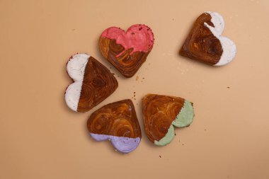 Yaratıcı idealler sevgililer günü düz açıda tatil kutlamaları yatıyordu. Kalp, bej arka planda farklı aromalı kruvasanlar şekillendirdi. Puf böreği yeni moda tatlı pastanesi