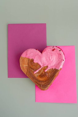 Sevgililer Günü bayramı hediyesi fikri. Lezzetli ve canlı kalp şeklinde kruvasan ikramı. Renkli kremayla kaplanmış. Uzayı kopyala Gıda deneyleri viral