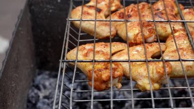 Barbeküde ızgara ızgarada kızarmış tavuk. Baharat taze ızgara tavuk kanatlarına dökülüyor. Yaz partisi yemekleri. Barbekü Sulu ızgara ızgarada kızarmış tavuk budu. 