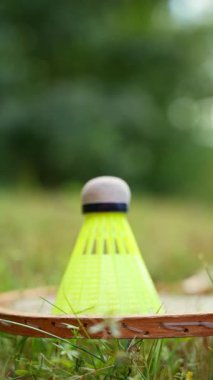 Badminton raketi ve mekik horozu yeşil çimlerin üzerinde yatar. Eğlence ve temiz hava dışında. Sağlıklı yaşam tarzı doğal bağlantı sporu yaz aktiviteleri. Stres atma hobisi sağlık hizmetleri