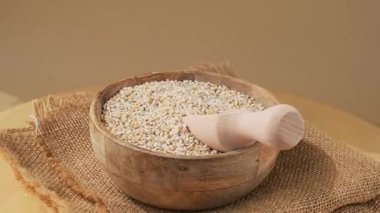 Tarafsız bej arka planda güzel bir arpa. Tam hecelenmiş tahıl türü. Yüksek proteinli lif zengini vejetaryen gıda bileşeni. Glütensiz süper yiyecekler sağlıklı beslenme alternatifleri