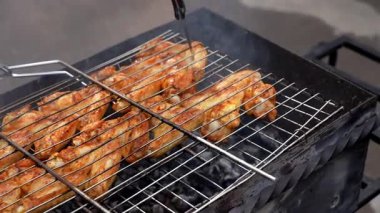 Barbekü pikniği zamanı kızarmış tavuk budu ve ızgarada kanat. Bahçe ızgarasında ızgara et. Bahçe bahçesinde yaz mevsiminde ızgara ızgara ızgara ızgara tavuk bifteği, dumanlı, sulu et.