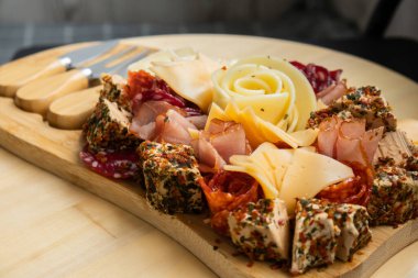 Gıda trend hediye aperatifi parti fikri. Aperatifler ahşap otlatma tahtası ile farklı şarküteri aperatifleri ve peynirler. Çeşit çeşit peynir tabağı. Düzensiz yemek. Kız yemeği.