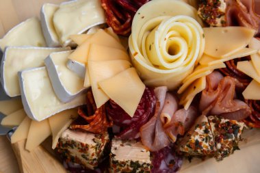 Peynir ve et şarküteri tahtası. Hediye hediyesi, öğle yemeği tabağı. Görsel olarak en az çaba gerektiren atıştırmalıklar. Özel peynir bıçaklarıyla basit bir yemek hazırlama. Tahta.