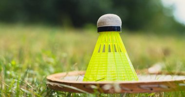 Badminton raketi ve mekik horozu yeşil çimlerin üzerinde yatar. Eğlence ve temiz hava dışında. Sağlıklı yaşam tarzı doğal bağlantı sporu yaz aktiviteleri. Stres atma hobisi sağlık hizmetleri