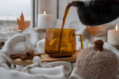 Mevsimlik kremalı kakao kahve ve tarçın Şükran Günü ve Hello Fall Cadılar Bayramı konsepti. Sonbahar tatilini pencerenin kenarındaki sıcak evde sonbahar yapraklarıyla kutluyoruz.