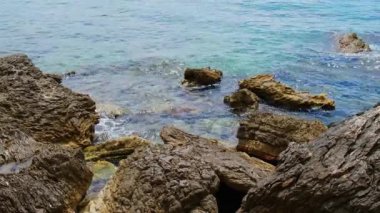 Karadağ 'ın Budva kenti yakınlarındaki katmanlı kayalar arasında güzel kayalar ve parlak turkuaz su bulunuyor. Adriyatik Denizi 'ndeki tropik yaz manzaralı egzotik plajlar. Tatil fikri. 