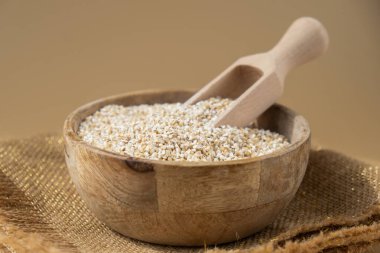 Tarafsız bej arka planda güzel bir arpa. Tam hecelenmiş tahıl türü. Yüksek proteinli lif zengini vejetaryen gıda bileşeni. Glütensiz süper yiyecekler sağlıklı beslenme alternatifleri