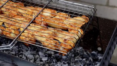 Barbekü pikniği zamanı kızarmış tavuk budu ve ızgarada kanat. Bahçe ızgarasında ızgara et. Bahçe bahçesinde yaz mevsiminde ızgara ızgara ızgara ızgara tavuk bifteği, dumanlı, sulu et.