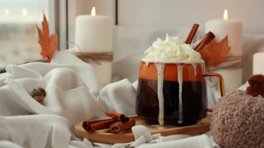 ASMR Balkabağı baharatlı latte sabah kahvesi. Cadılar Bayramı için Sonbahar İçkileri Şükran Günü Tatil içeceği Sonbahar baharatlı tarçın aromalı sıcak mevsimlik sıcak içecekler sıcak turuncu bardakta. Soğuk atmosfer