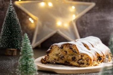 Noel ışıkları ve dekorasyonuyla çalınmış Noel. Geleneksel meyveli somun şekerli, şenlikli tatlı. Tatil pişirme konsepti. 