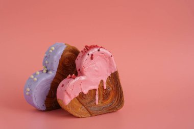 Sevgililer Günü bayramı hediyesi fikri. Lezzetli ve canlı kalp şeklinde kruvasan ikramı. Renkli kremayla kaplanmış. Uzayı kopyala Gıda deneyleri viral