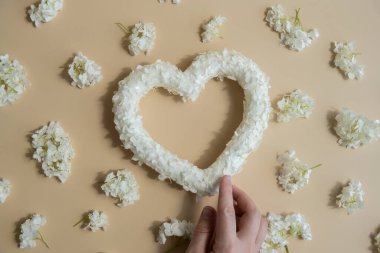 Aşkın sembolü. Bej arka planda kalp şeklinde çiçek yaprakları. Sevgililer Günü 'nün yaratıcı konsepti, romantik bir tarih ya da yıldönümü. Boşluk tebrik kartını kopyala