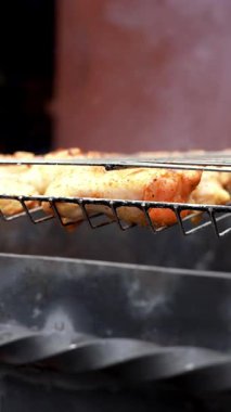 Barbekü pikniği zamanı kızarmış tavuk budu ve ızgarada kanat. Bahçe ızgarasında ızgara et. Bahçe bahçesinde yaz mevsiminde ızgara ızgara ızgara ızgara tavuk bifteği, dumanlı, sulu et.