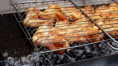 Barbeküde ızgara ızgarada kızarmış tavuk. Baharat taze ızgara tavuk kanatlarına dökülüyor. Yaz partisi yemekleri. Barbekü Sulu ızgara ızgarada kızarmış tavuk budu. 