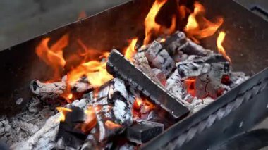 Barbekü ızgarasında alevler arka bahçede boş zaman aktiviteleri. Yaz tatili partisi kavramı Yavaş çekim yanan odunları bbq yemek pişirmeye hazırlıyor Yaz zamanı