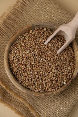 Tarafsız bej arka plan fotokopi alanında çiğ karabuğday lapası. Tam hecelenmiş tahıl türü. Yüksek proteinli lif zengini vejetaryen gıda bileşeni. Glütensiz süper yiyecek sağlıklı beslenme