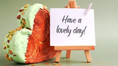 Yeşil arkaplanlı ve fotokopi alanı olan, kalp şeklinde şam fıstıklı kruvasan dolu bir tebrik kartı alın. Puf puf yeni moda tatlı pastanesi. Kremalı hamur deneyi 