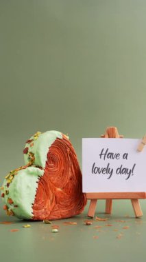 Yeşil arkaplanlı ve fotokopi alanı olan, kalp şeklinde şam fıstıklı kruvasan dolu bir tebrik kartı alın. Puf puf yeni moda tatlı pastanesi. Kremalı hamur deneyi 