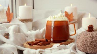 Sonbahar higge turuncu kahve fincanı masadaki sıcak kahve yaprakları yağmur damlalarına karşı penceredeki bardaktan aşağı akıyor. Samimi düşüşün canlı görüntüleri mum yakıyor. Şükran Günü ve Cadılar Bayramı