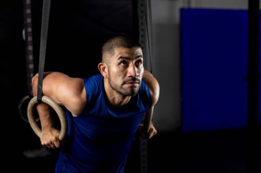 Spor kıyafetleri içinde spor salonunda jimnastik yapan Latin bir adam.