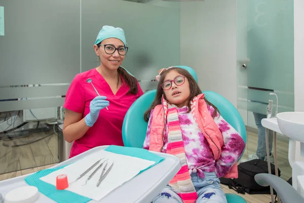 一个女牙医和她的病人在她的牙科诊所里 看着相机的肖像 — 图库照片