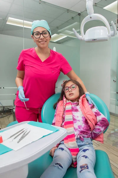一名女牙医在治疗后与她的病人在牙科诊所的垂直画像 — 图库照片