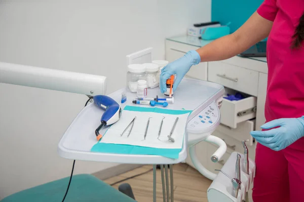 接近一套牙科器具 并由牙医人手安排 — 图库照片