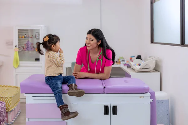 彼女の医務室で女の子を見ている間に女性小児科医笑顔 — ストック写真