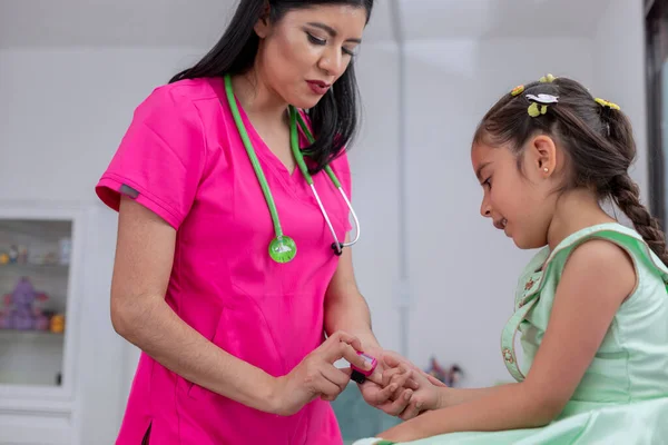 Joven Pediatra Latina Examinando Una Niña Oficina Con Oxímetro — Foto de Stock