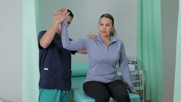 Médecin Thérapeute Levant Bras Une Femme Assise Sur Civière Clinique — Video