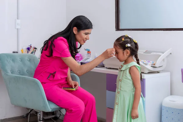 儿科医师在一个女孩会诊后 在她的额头上涂了颗星星 — 图库照片