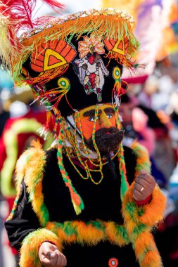 Meksika 'da bir karnavalda Chinelo kostümüyle dans eden biri ellerini hareket ettiriyor.