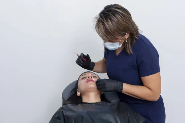 美容师将透明质酸疗法应用于年轻女性的唇上 用注射器注射 带有复制空间 — 图库照片