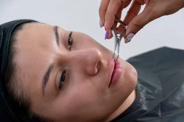 靠近一个年轻女人的脸 她的嘴唇被测量注射透明质酸 — 图库照片